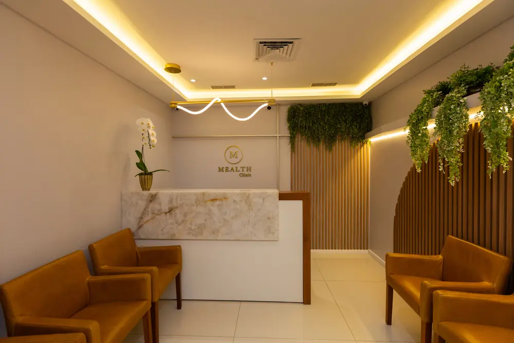 Recepção da Mealth Clinic com sofás e iluminação acolhedora