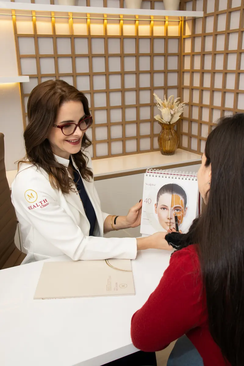 Dermatologista conversando com paciente durante a consulta